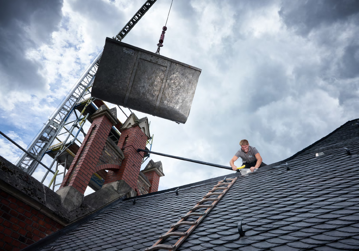 Dachdecker von Meyendriesch-Dach bei der Schiefereindeckung am Alten Rathaus Bonn-Oberkassel – Materialanlieferung per Kran auf das historische Gebäude