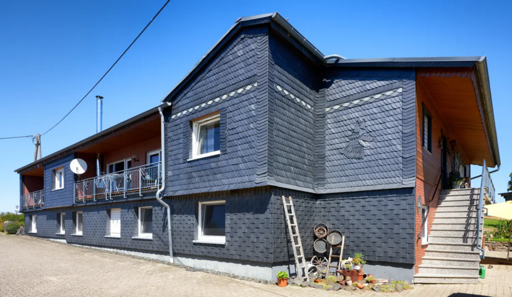Vollständig in Schiefer verkleideter Bauernhof in Mörsdorf im Hunsrück – Dach und Fassade mit dekorativem Schiefermuster, ausgeführt von Meyendriesch-Dach